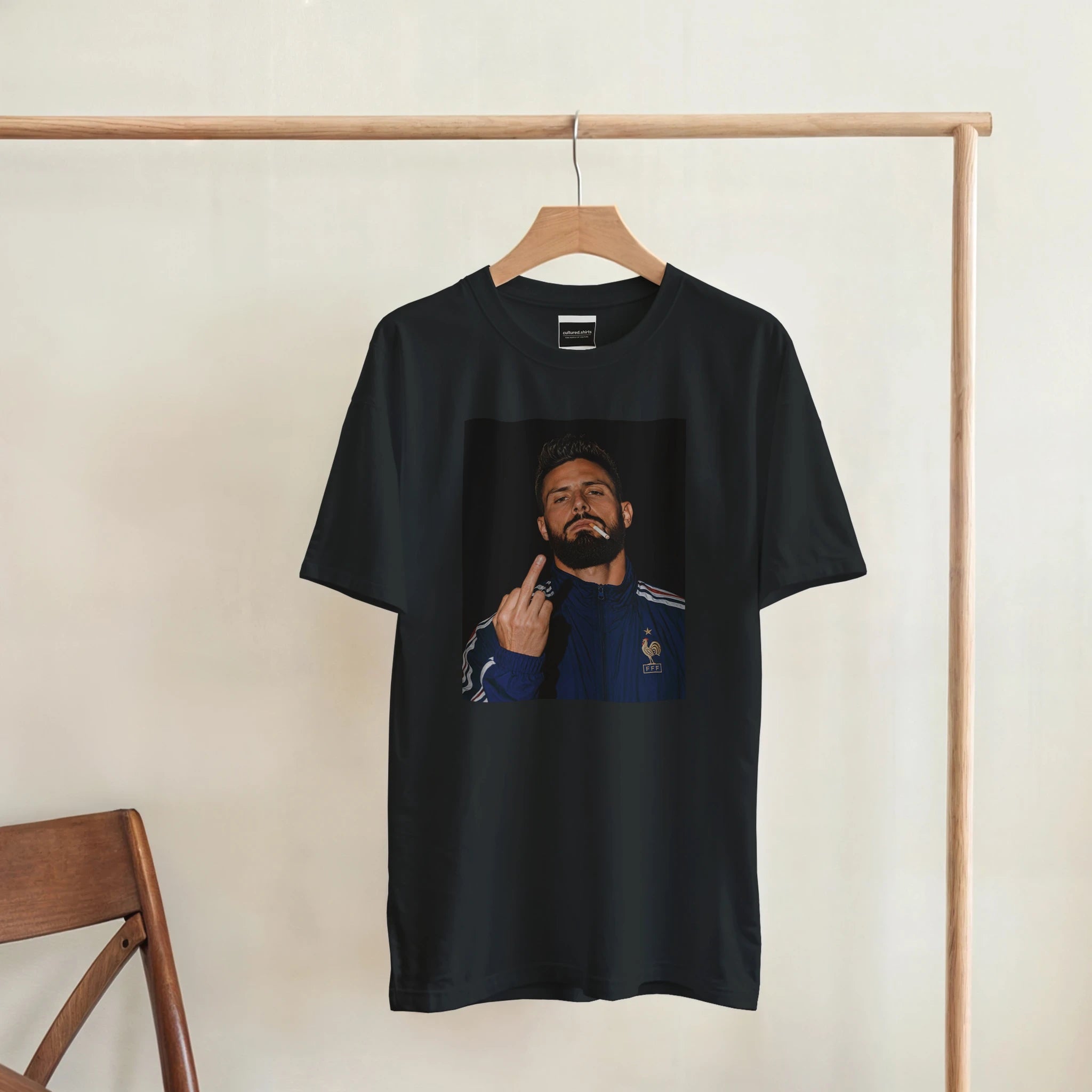 Black T-shirt hanging with front portrait graphic of a bearded man in a blue jacket