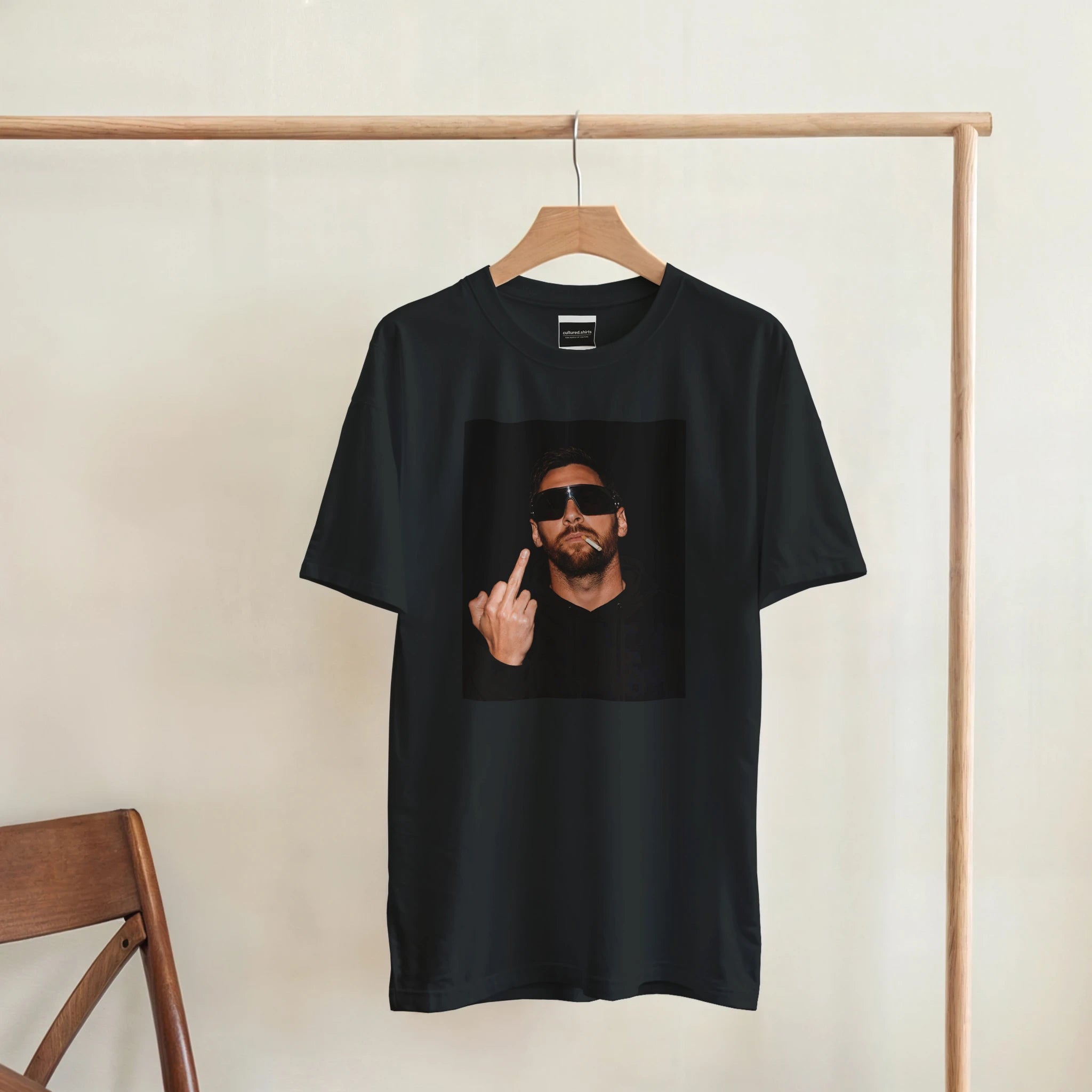 Black men’s T-shirt hanging on a wooden hanger with square portrait peace sign print
