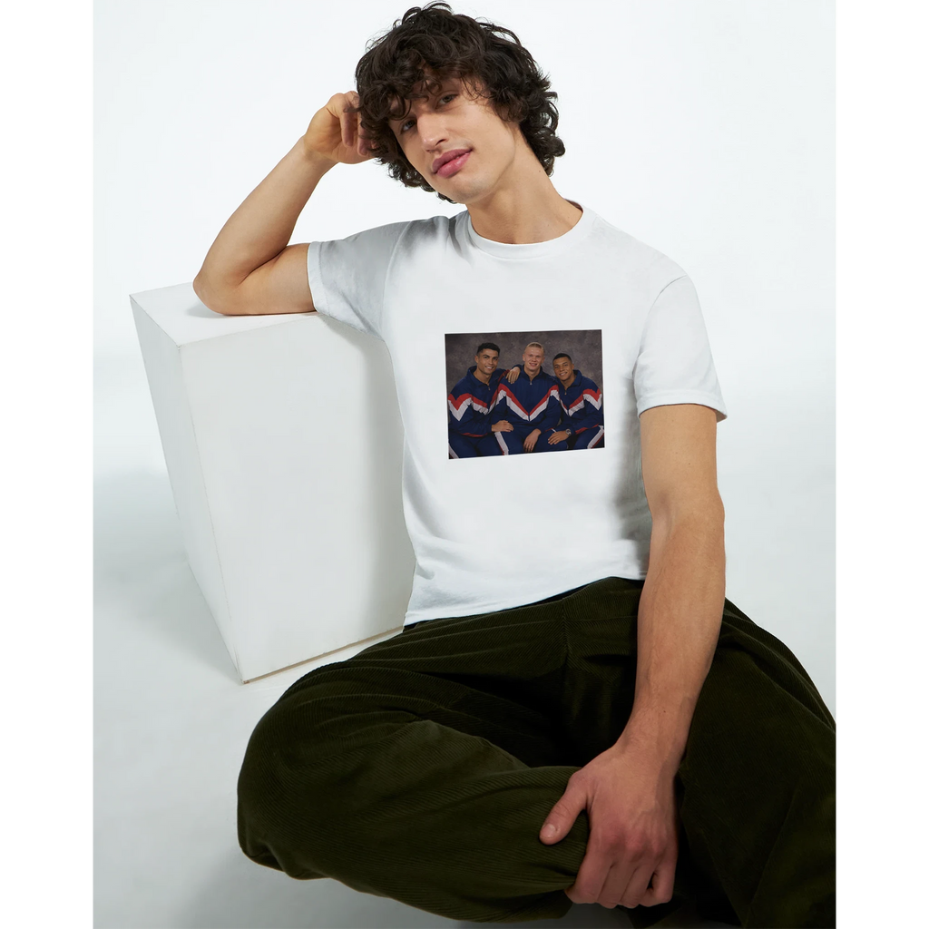 White crewneck T-shirt with retro soccer player graphic, worn by seated model.