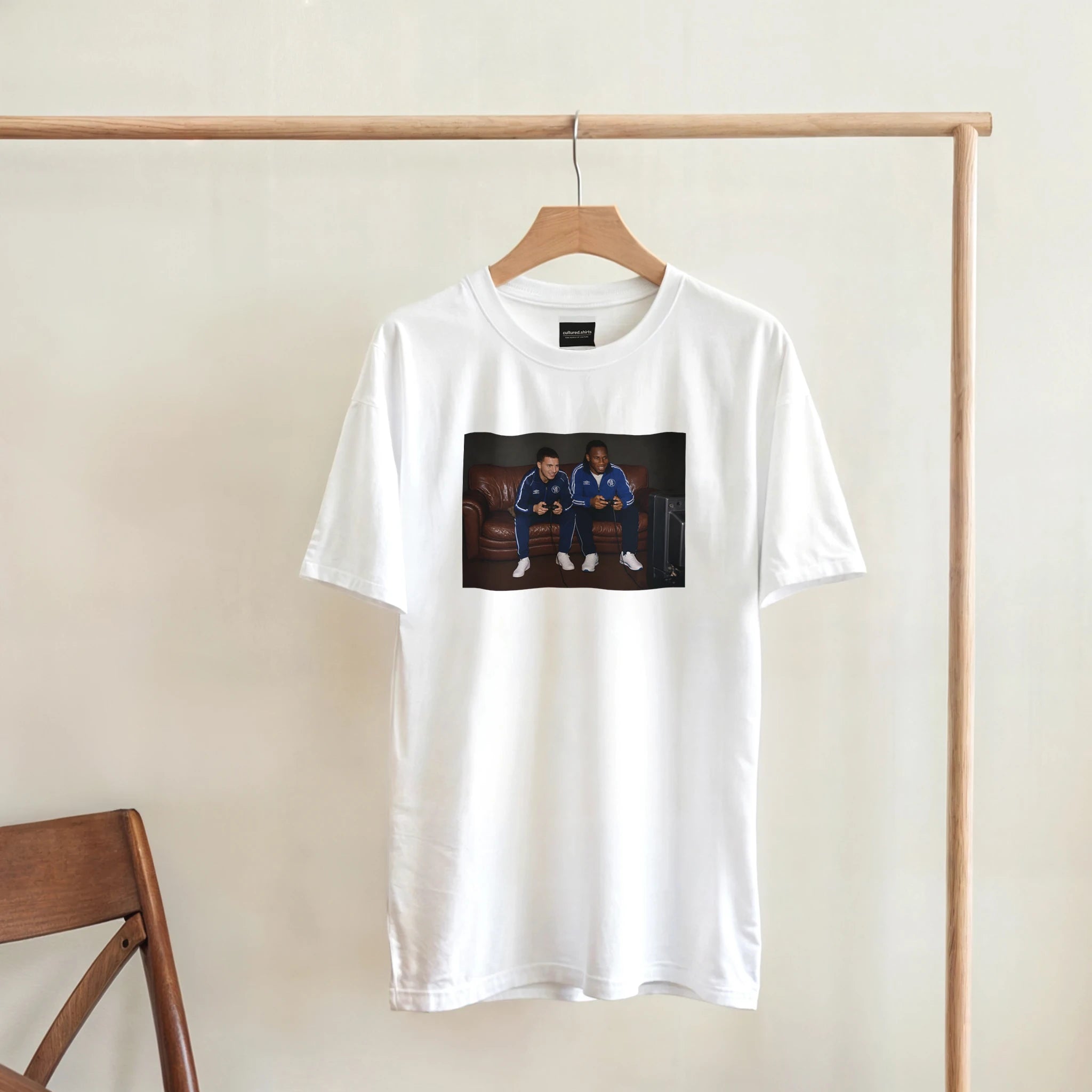 White T-shirt with rectangular player graphic, hanging on wooden hanger