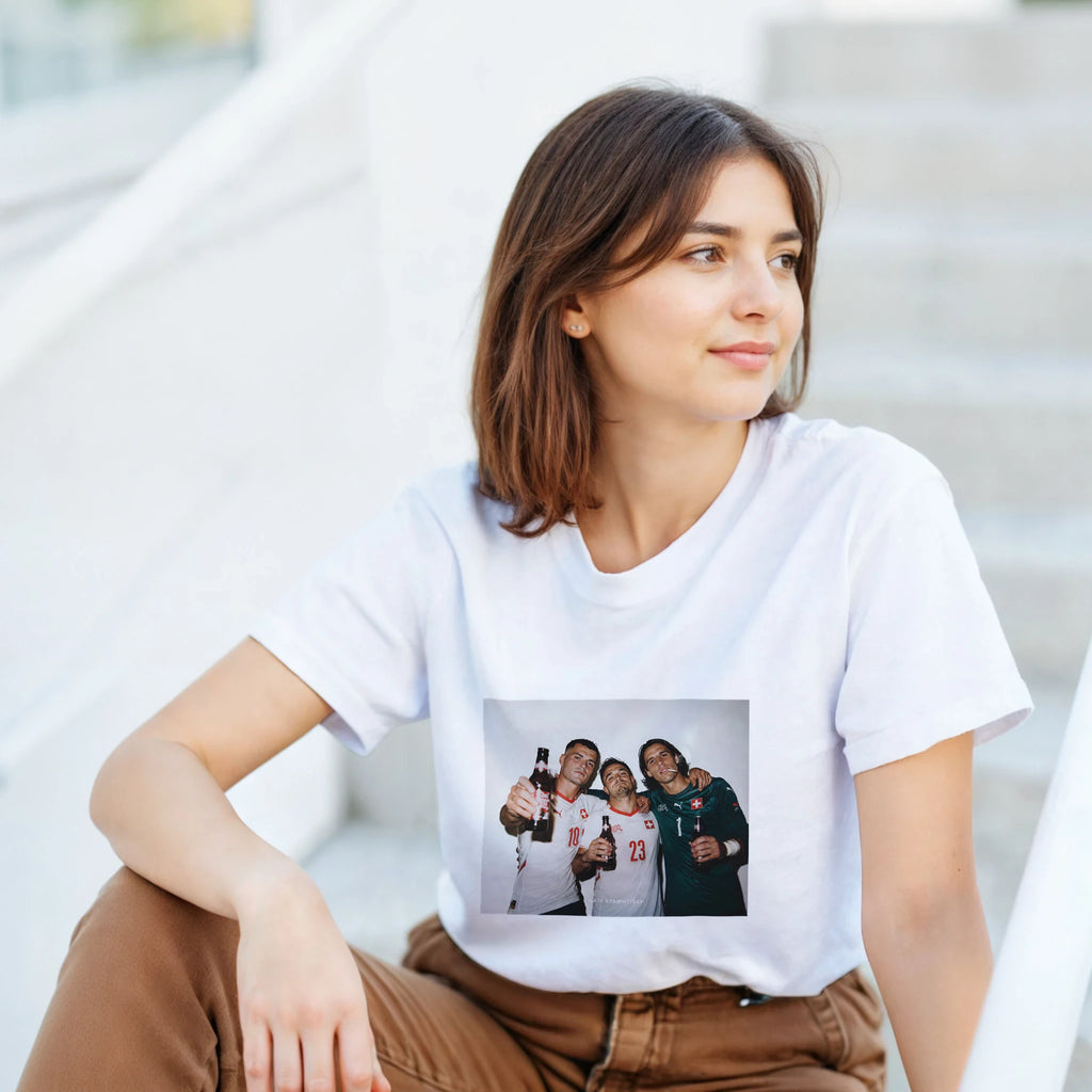 White T-shirt worn by a woman with a rectangular graphic print of three football players