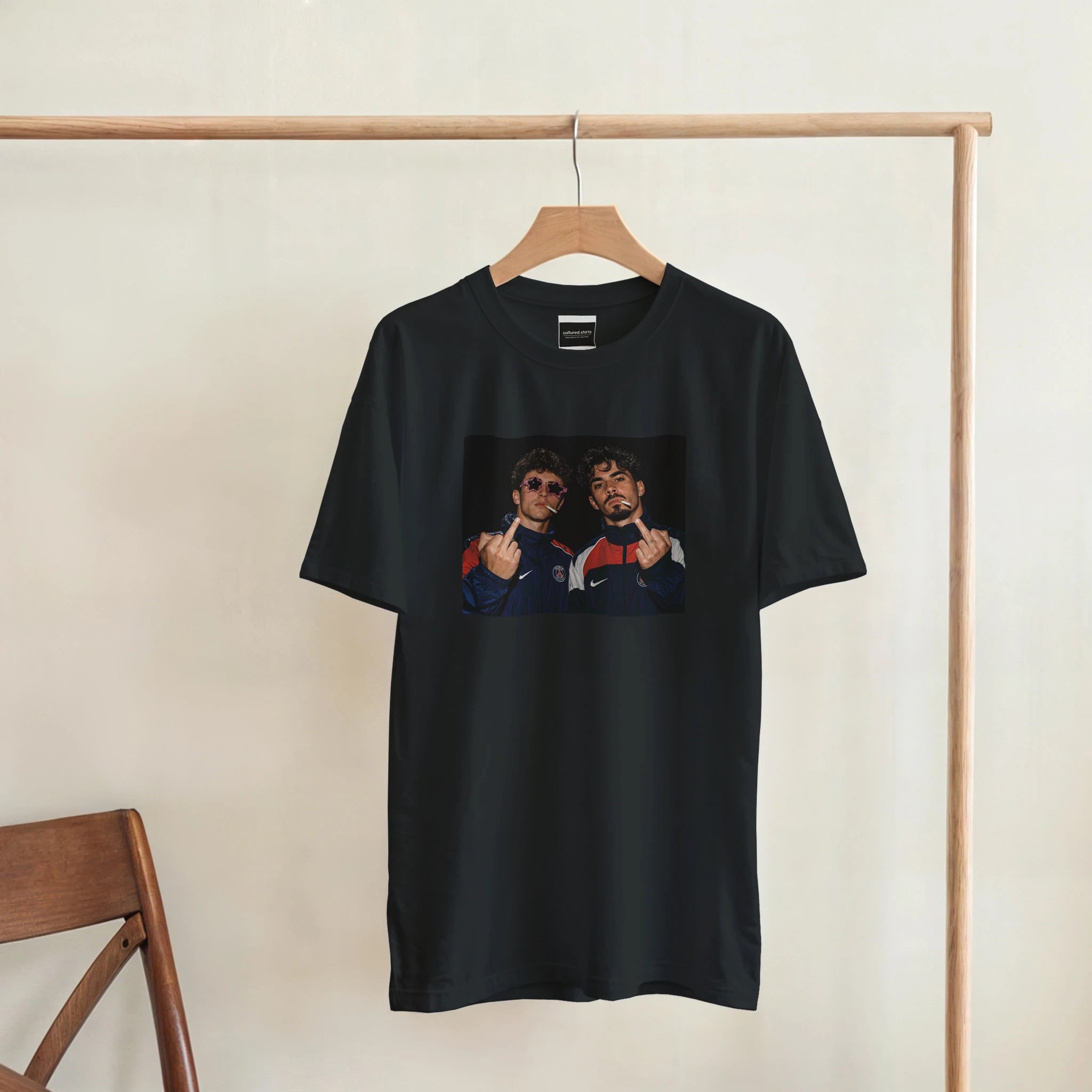 Black T-shirt hanging on a wooden rack with centered player graphic