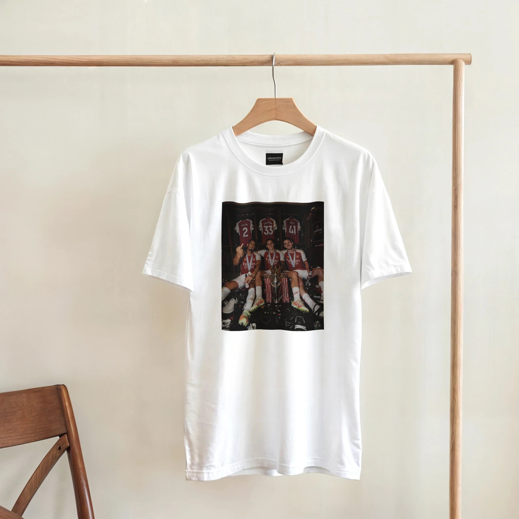 White graphic T-shirt on wooden hanger with rectangular team photo print
