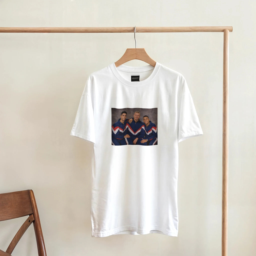 White crewneck T-shirt hanging on wooden hanger, retro soccer player graphic.